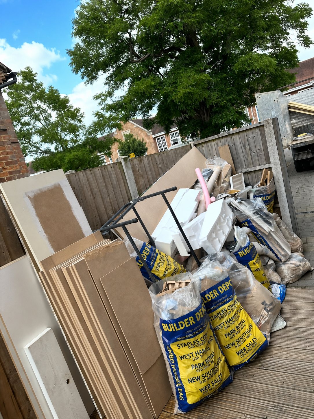 Timber deck filled with boards, bags and builders waste before clearance